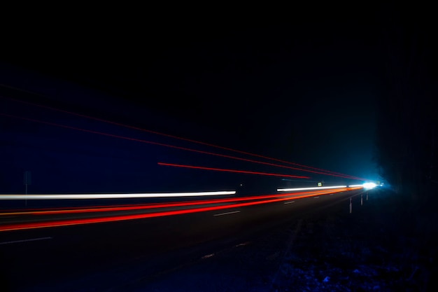 Luzes vermelhas e brancas dos carros que passavam. Estrada noturna.