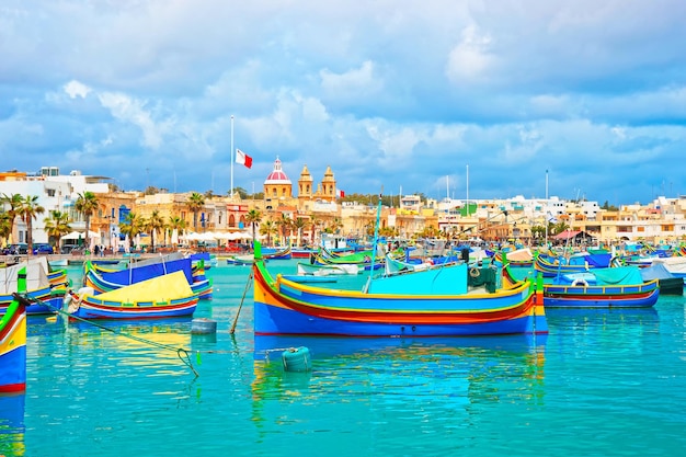 Luzzu bunte Boote am Hafendamm von Marsaxlokk in der Bucht des Mittelmeers, Insel Malta