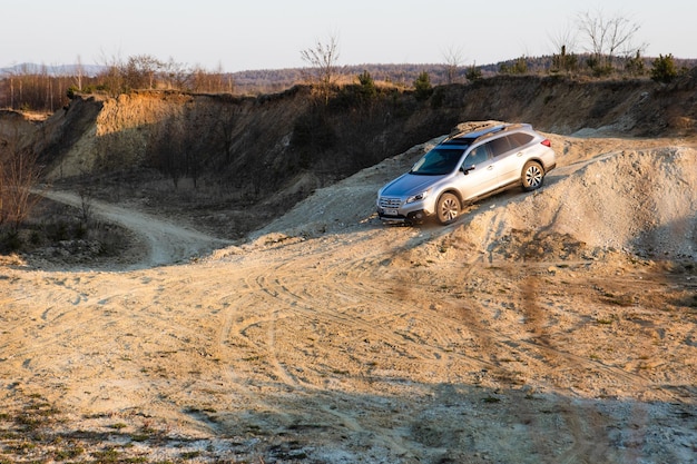 Foto lviv ucrânia 7 de abril de 2020 carro subaru outback suv descendo por colina empoeirada