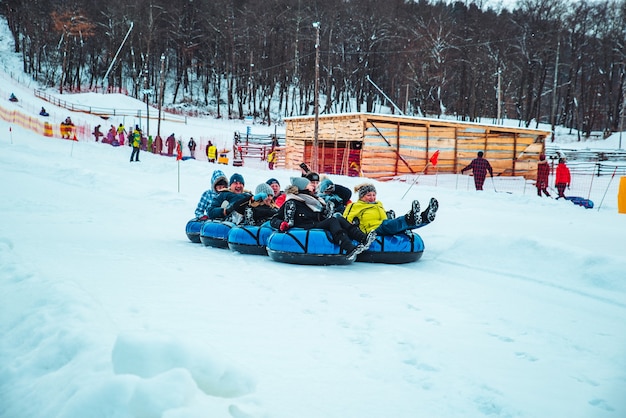 Lviv, ucrânia - 7 de janeiro de 2019: atividades divertidas de inverno. desça pela colina em um tubo de neve. empurrando