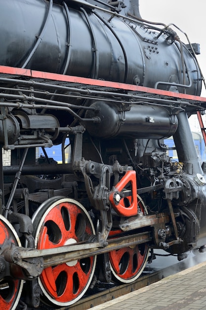 LVIV, Ucrania - diciembre de 2015: Antiguo tren retro negro vintage soviético L-3535 en la estación de tren de Lviv produce vapor de las tuberías