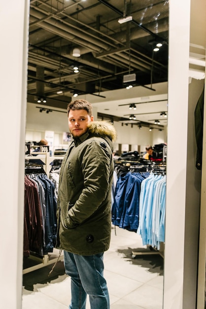 LVIVRAINE 27 de octubre de 2018 hombre probando una nueva chaqueta de invierno tienda de moda