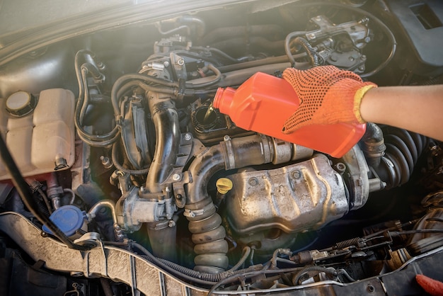 Ölwechsel im Autoservice. Schutzhandschuh mit Ölflasche abgeben