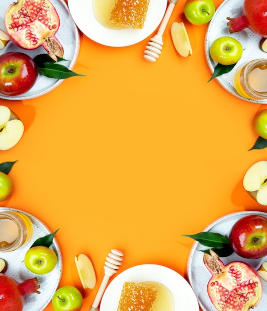 Foto maçã com mel e romã em um fundo laranja conceito do ano novo judaico rosh hashaná