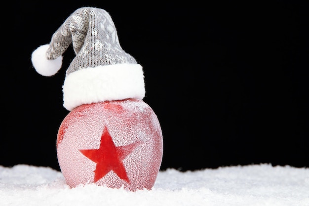 Maçã de férias com estrela fosca na neve em fundo preto