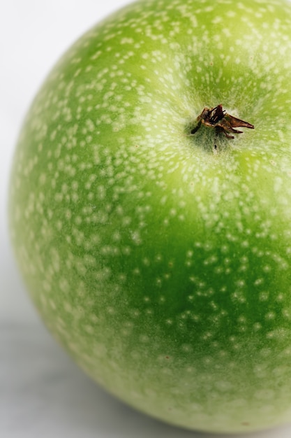 Foto maçã de granny smith verde com pontos brancos na casca. macro, foco seletivo