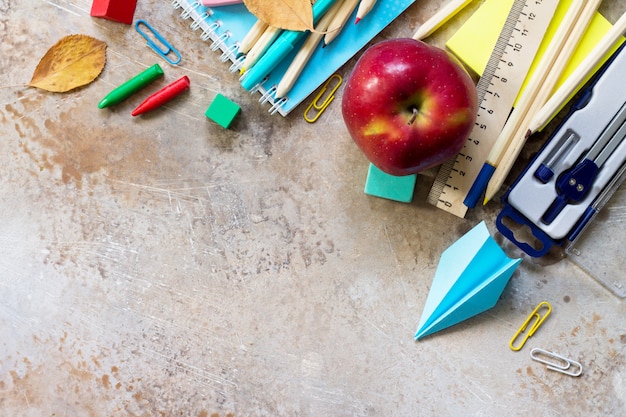 Maçã e material escolar em uma mesa