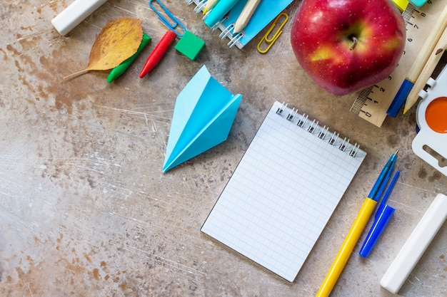 Maçã e material escolar em uma mesa