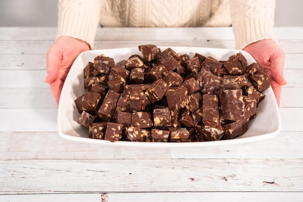 Macadamianuss-Fudge in kleine Würfel schneiden.