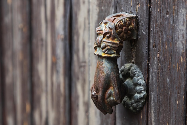 Maçaneta de porta antiga em forma de mão fechada