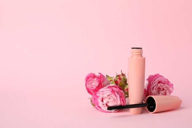 Macara y flores sobre fondo rosa. Accesorios femeninos