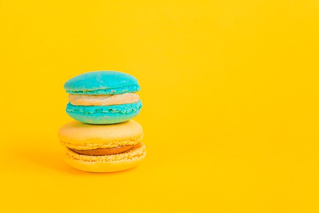 Macaron amarelo azul de unicórnio colorido de amêndoa doce ou bolo de sobremesa macaroon isolado na moda moderna amarela