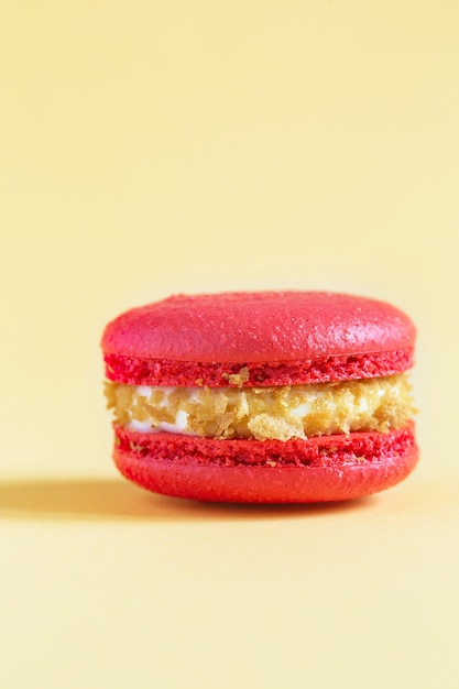 macaron de bolo vermelho ou macaroon na parede amarela. biscoitos de amêndoa coloridos. bolo de macaroon francês