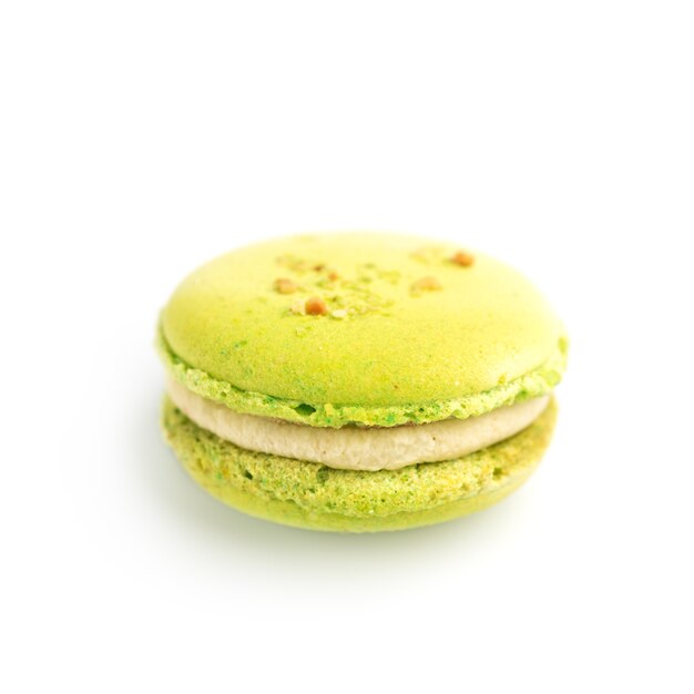 Macaron de farinha de amêndoa assada verde redondo isolado em um fundo branco, deliciosa sobremesa francesa popular