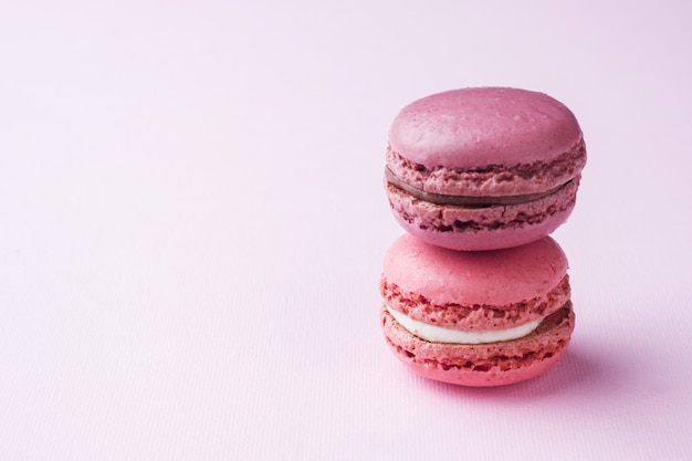 Macaron de sobremesa-de-rosa ou macaroons em fundo rosa