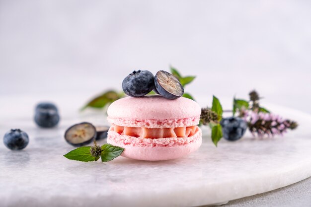 Macaron-Keks mit Beeren, süßer Sommerdessert. Auf grauem Hintergrund