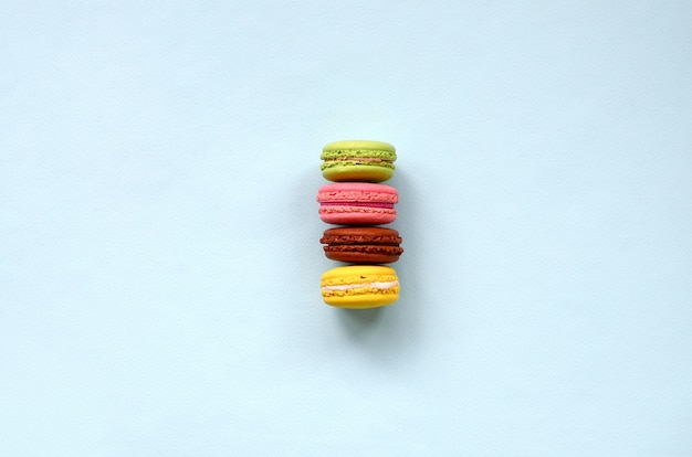 Macaron o macarrones de la torta del postre en la opinión superior del fondo azul en colores pastel de moda.
