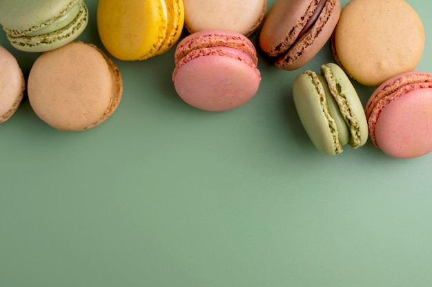Macarons biscoitos coloridos Macarons na tigela sobremesa doce francesa vista superior fundo verde Copiar espaço
