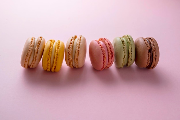 Macarons biscoitos coloridos macarons sobremesa doce francesa vista superior fundo rosa copie o espaço