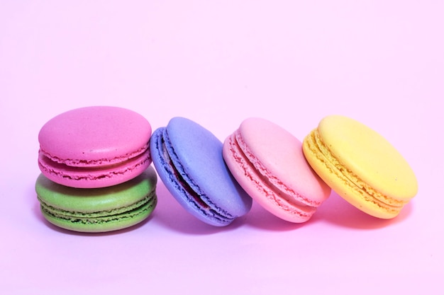 Macarons de colores sobre un fondo rosa