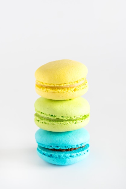 Macarons coloridos amarelo azul verde macarons sobremesa francesa macarons saborosos fundo branco vertical