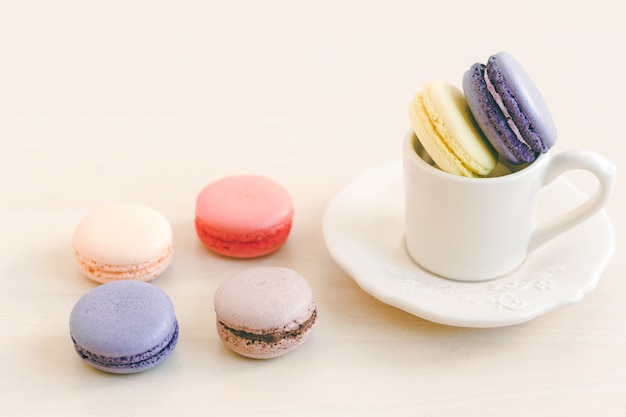 Macarons coloridos diferentes na xícara de chá