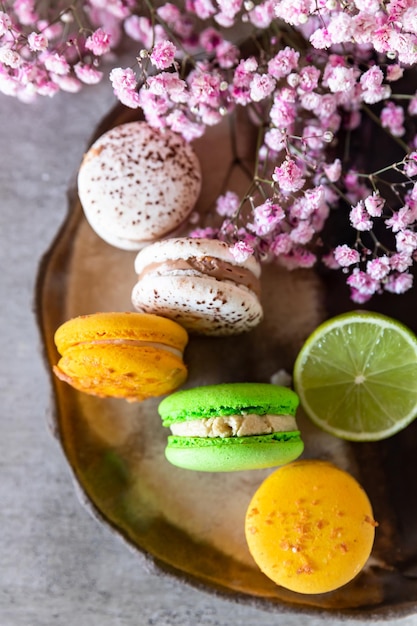 Foto macarons coloridos franceses ou italianos com limão e flores comida doce fundo