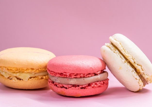 Macarons de biscoitos franceses em fundo rosa bolo de biscoitos doces de amêndoa de frutas saborosas macaron