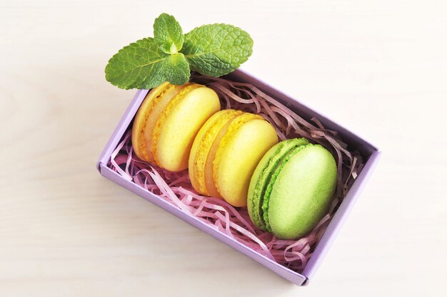 Macarons de bolo amarelo e verde com hortelã na caixa