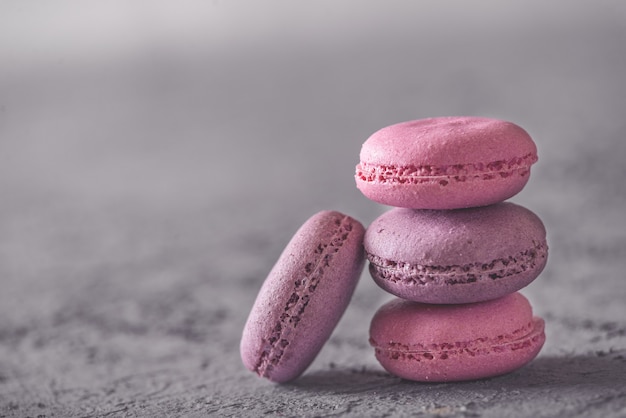 Foto macarons de sobremesas deliciosas e coloridas bonitas, empilhadas na pedra cinza