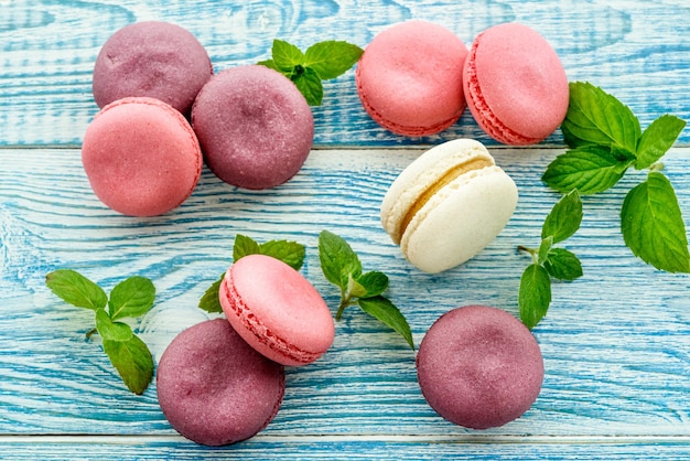 Macarons doces em um fundo azul Bolos na moda