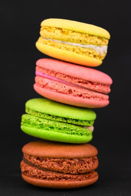 Macarons em um fundo preto macaroons coloridos franceses close