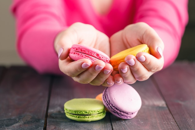 Macarons in den Händen der Frau gefärbt