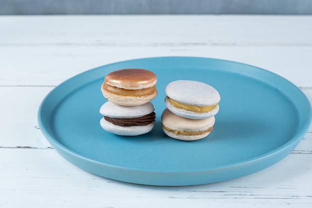 Macarons mit Schokoladen-Ganache-Füllung und Dulce de Leche auf einem blauen Teller gestapelt