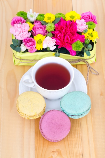 Macarons mit Teetasse und Blumen