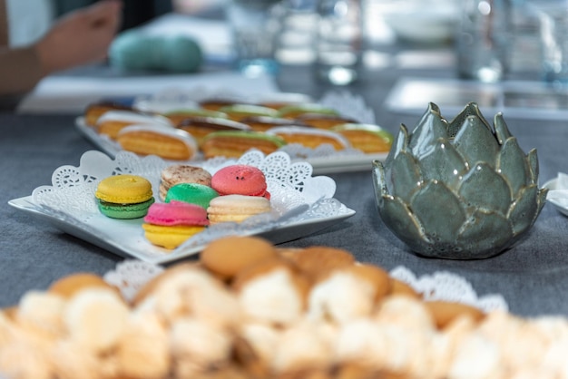 Macarons na mesa festiva. Prato com guardanapo a céu aberto. castiçal em forma de flor