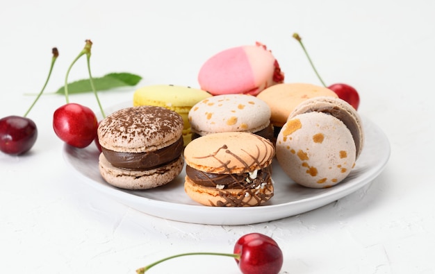 Macarons redondos assados em um prato de cerâmica branca em um prato branco