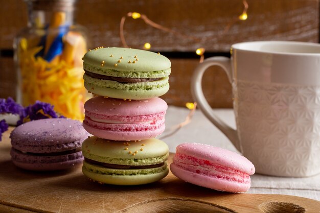 Macarons y taza de café en la mesa de madera