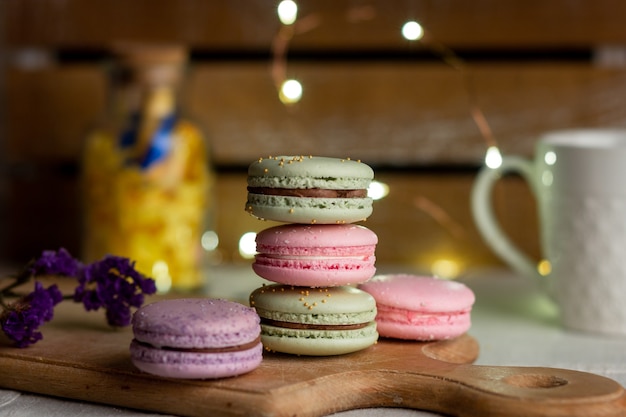 Macarons y taza de café en la mesa de madera