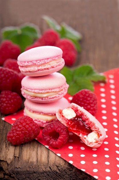 Macaroon com biscoitos de framboesas em um fundo de madeira