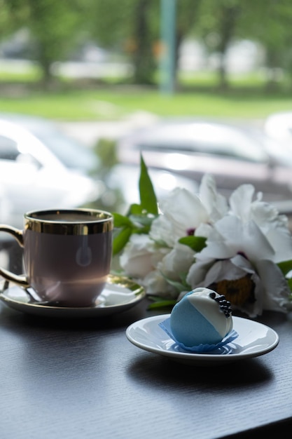 Macaroon com xícara de café e flores na mesa no café Café da manhã com massa