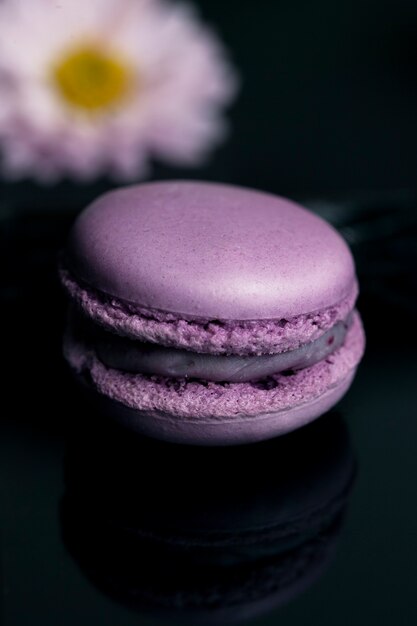 Macaroon roxo doce isolado em fundo preto