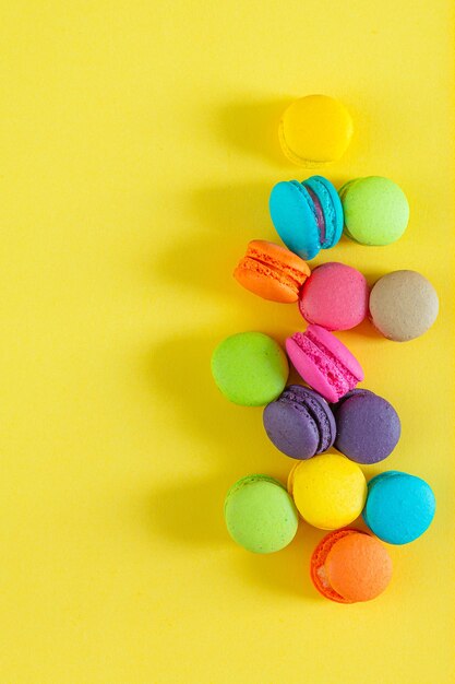 Macaroons coloridos doces em fundo amarelo macaroons franceses doces e coloridos