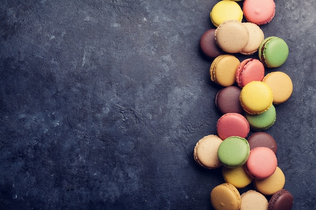 Foto macaroons coloridos na mesa de pedra