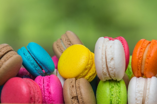 Macaroons coloridos no prato na mesa de madeira