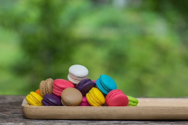 Foto macaroons coloridos no prato na mesa de madeira