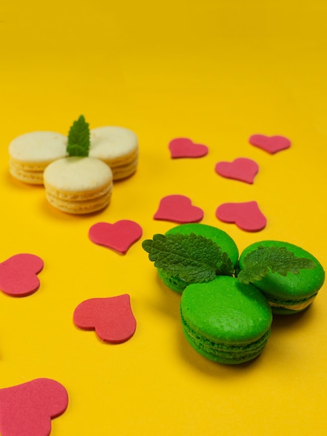 Foto macaroons coloridos sobre um fundo amarelo. conceito para o feriado. copie o espaço