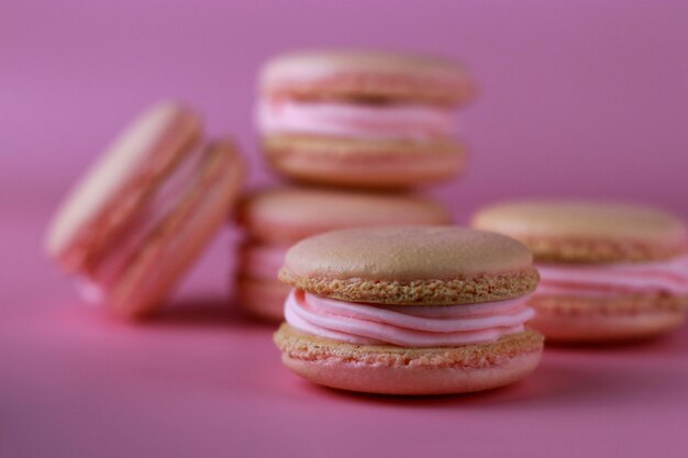 macaroons com creme de manteiga rosa em um fundo rosa