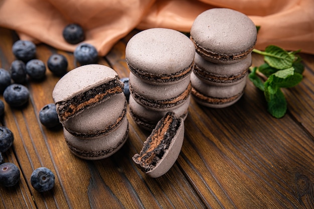 Macaroons com frutas em uma mesa de madeira