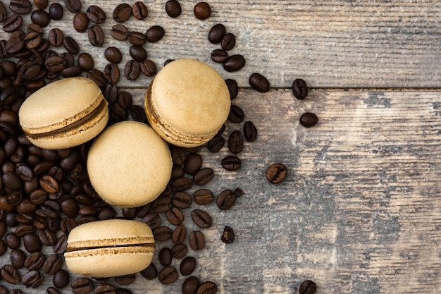 Macaroons de café e grãos de café na mesa de madeira